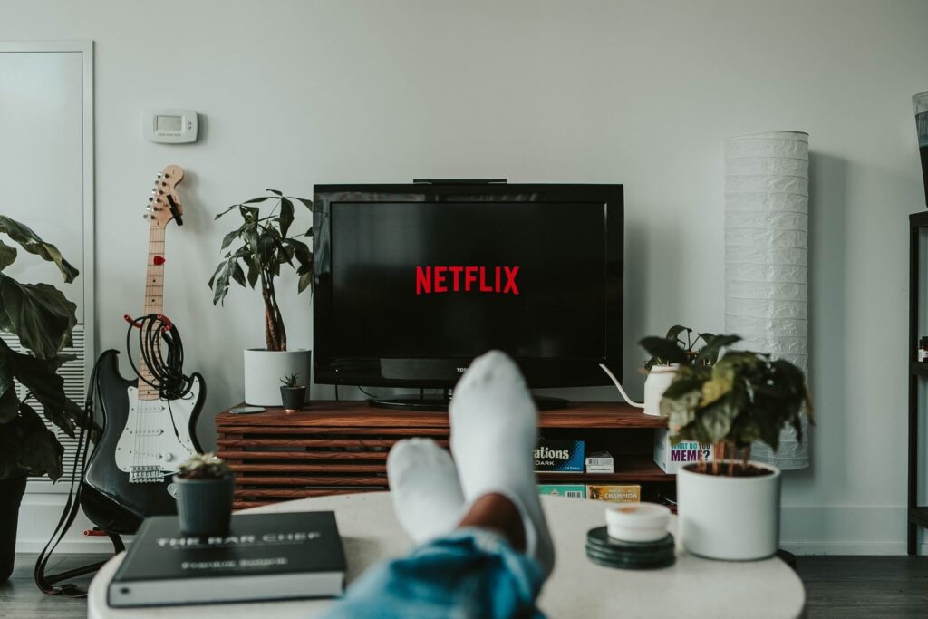 Pessoa assistindo Netflix na sala de casa