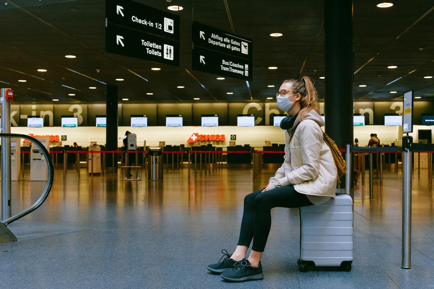 Mulher de máscara esperando voo em aeroporto