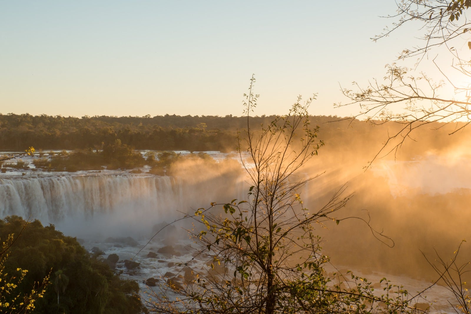 A foto mostra as luzes adentrando o amanhecer nas cataratas