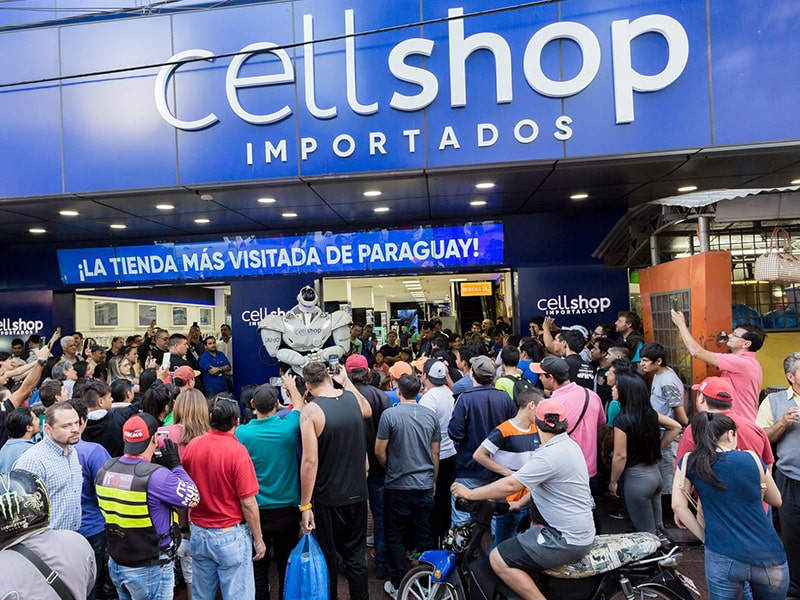Crazy Week: A foto mostra a fachada da Loja Cellshop no Paraguai com várias pessoas na frente.