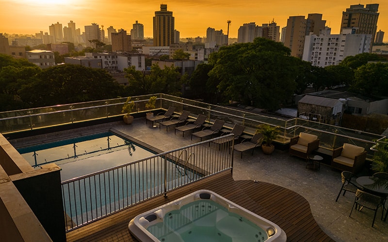 A foto mostra a área de lazer do Del Rey Quality Hotel, composta por piscina aquecida e jacuzzi.