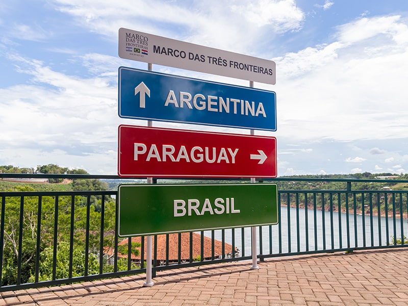 A foto mostra as placas do Marco das Três Fronteiras que liga Argentina, Paraguai e Brasil.