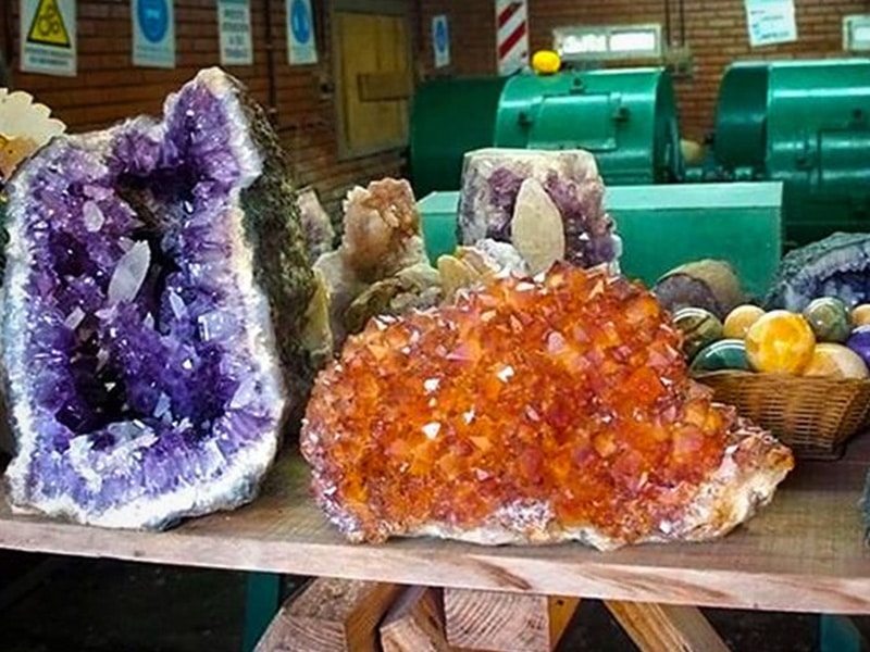 A foto mostra dois cristais, um roxo e outro laranja.