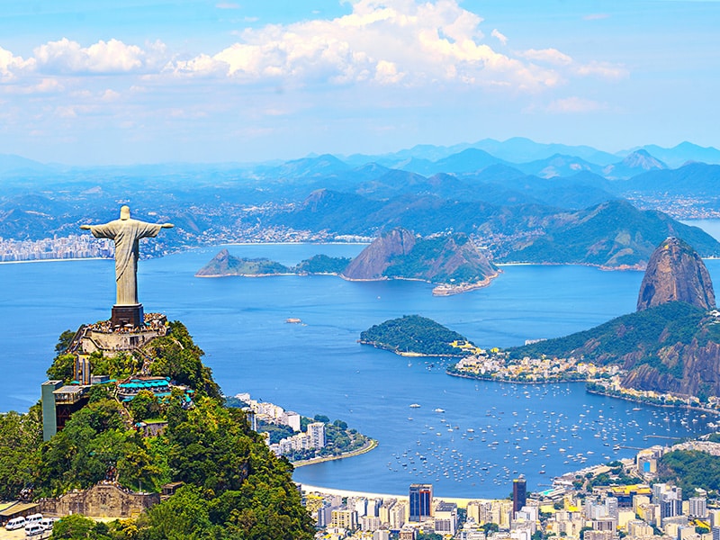 A imagem mostra paisagens do Rio de Janeiro, com o Pão de Açúcar e o Cristo Redentor.
