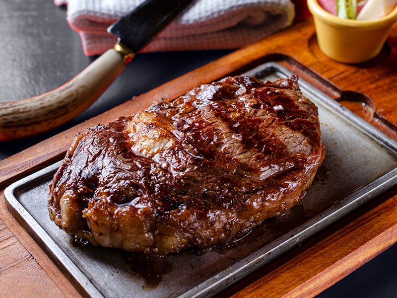 Um famoso Jantar na Argentina, a foto mostra uma carne feita na parrilha no estilo argentino.